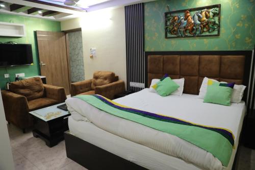 a bedroom with a large bed and a living room at Hotel Prem Residency in Patna