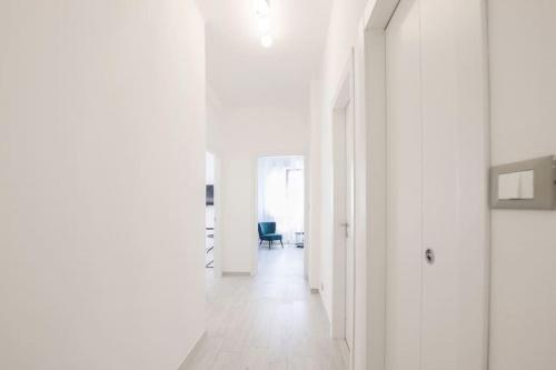un corridoio con pareti bianche, pavimenti bianchi e una sedia di La dolce vita - Pescara Centro a Pescara