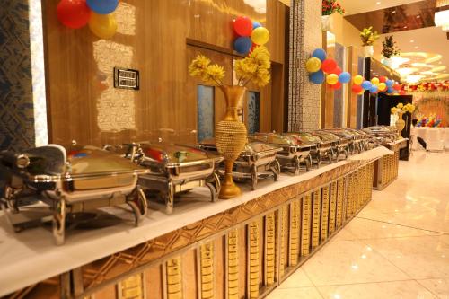 una fila de mesas en un restaurante con globos en Hotel Prem Residency, en Patna