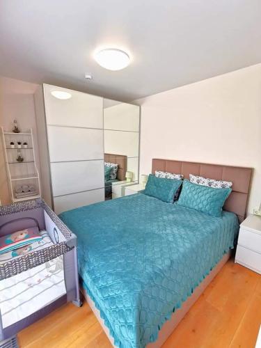 a bedroom with a large bed with a blue comforter at Cozy Palanga in Palanga