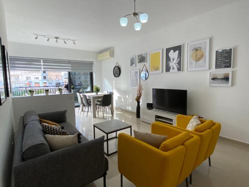 a living room with two couches and a tv at Mellieha sea and land view apartment in Mellieħa