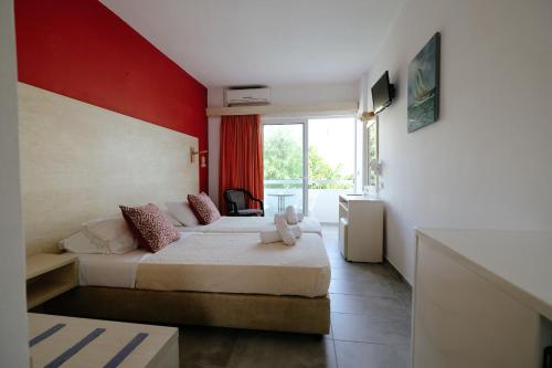 1 dormitorio con 2 camas y pared roja en Helena Hotel en Rodas