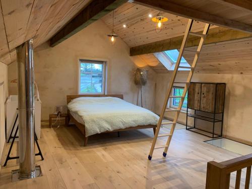 1 dormitorio con cama elevada y escalera en L'Oeil du Condroz en Clavier