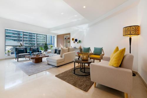 a living room with white furniture and a large window at Maison Privee - Stunning 3-Floor Villa with Kids Room & Rooftop Terrace over Dubai Marina in Dubai