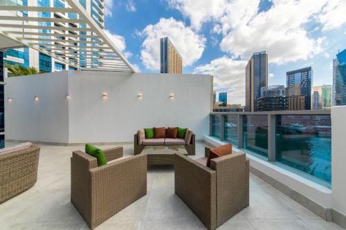 a rooftop patio with chairs and a view of the city at Maison Privee - Stunning 3-Floor Villa with Kids Room & Rooftop Terrace over Dubai Marina in Dubai