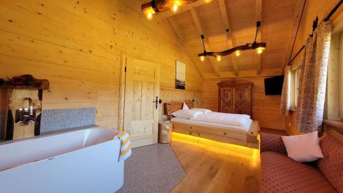 een slaapkamer met een bed in een houten hut bij Chalet Bauer in Drachselsried