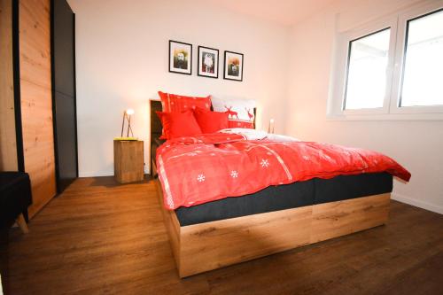 a bedroom with a large bed with red pillows at BLACKFOXREST Ferienwohnung in Feldberg