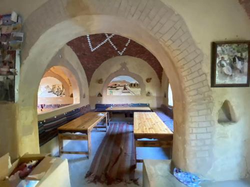 una sala da pranzo con tavoli e un muro di mattoni di Mountain Camp Ali Khaled a Siwa