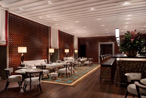 a restaurant with tables and chairs and a bar at Portrait Milano - Lungarno Collection in Milan
