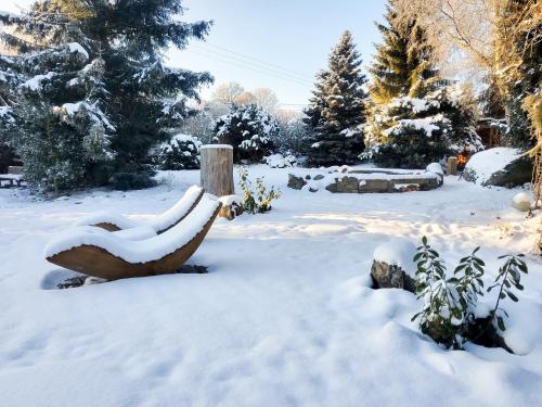 a bench covered in snow in a garden at Chatka Mileč in Nepomuk