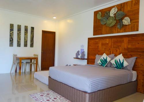 um quarto com uma cama grande e uma cabeceira em madeira em Gem's Paradise Resort em Cebu