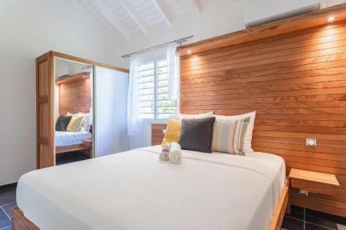 sypialnia z dużym łóżkiem z drewnianym zagłówkiem w obiekcie Villa Orchidées w mieście Sainte-Anne