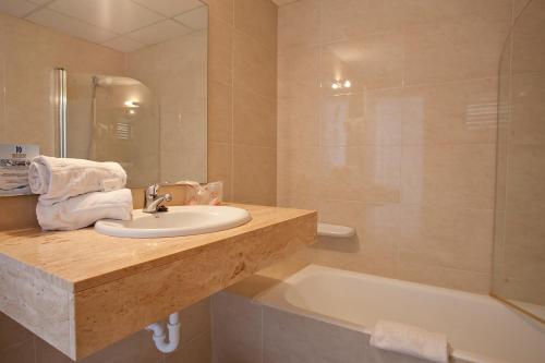 a bathroom with a sink and a bath tub at Aparthotel Playa Dorada in Sa Coma