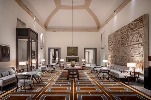 a living room with couches and tables and a fireplace at Portrait Milano - Lungarno Collection in Milan
