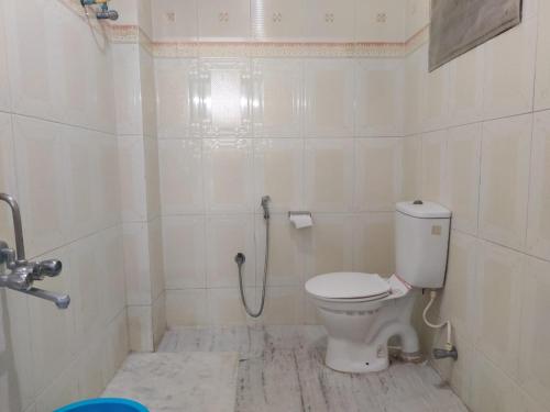 Roshini Serviced Apartments في تشيناي: حمام ابيض مع مرحاض ودش