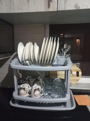 a shelf with plates and utensils on a table at White House Executive - Guest House Islamabad in Rawalpindi