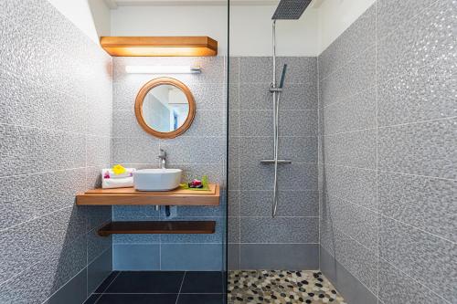 La salle de bains est pourvue d'une douche, d'un lavabo et d'un miroir. dans l'établissement Villa Plumbago, à Sainte-Anne