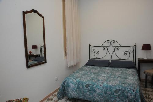 1 dormitorio con cama y espejo en la pared en Massimino, en Palermo