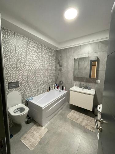La salle de bains est pourvue d'une baignoire, de toilettes et d'un lavabo. dans l'établissement City View Apartment, à Constanţa