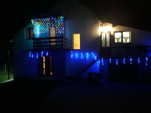 a house with blue lights on it at night at Casa Popa in Gura Humorului