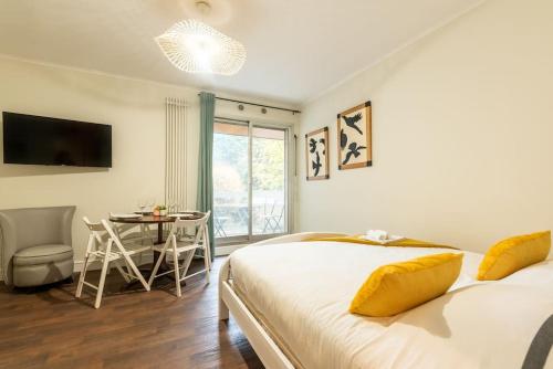 a bedroom with a bed and a table with a chair at Appartement proche Champs Elysées in Paris