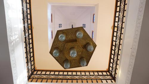 a mirror hanging on a wall in a room at Saphir Paon - Luxury Villa in the middle of a farm in Dar Achachir