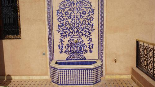 a blue and white tile wall with a vase on it at Saphir Paon - Luxury Villa in the middle of a farm in Dar Achachir