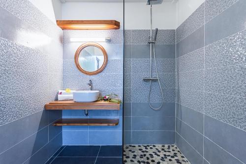 ein Bad mit einem Waschbecken und einer Dusche in der Unterkunft La villa Hibiscus in Sainte-Anne