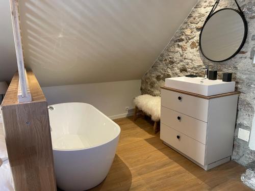 La salle de bains est pourvue d'une baignoire blanche et d'un lavabo. dans l'établissement Ferme de Soulan, gîte de charme, à Saint-Lary-Soulan