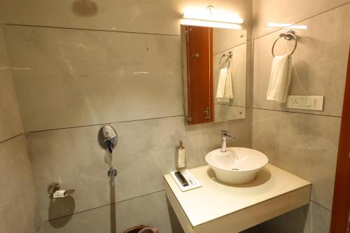 ein Bad mit einem Waschbecken und einem Spiegel in der Unterkunft Hotel Darbar-E-Khas A member of Crimson Hotels in Bareilly