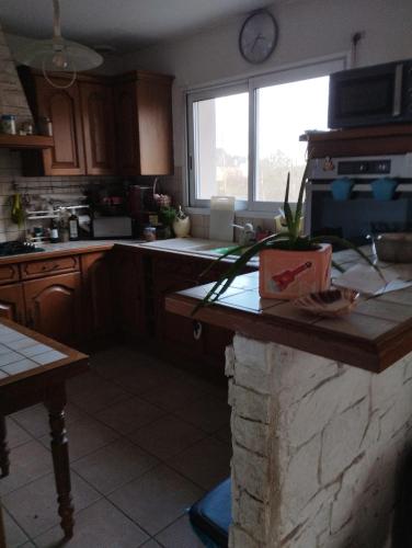 a kitchen with a counter and a window in it at les Mésanges bleues in Saint-Jouan-de-lʼIsle