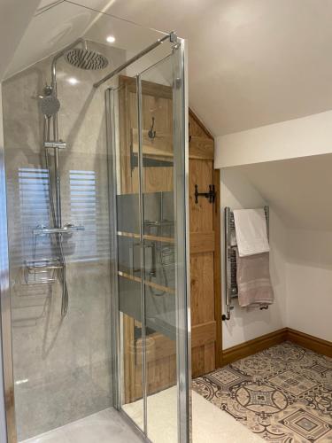 uma casa de banho com uma cabina de duche em vidro. em Swallows Rest em Leek