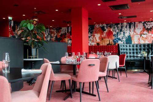 a dining room with pink chairs and tables at ProfilHotels Halmstad Plaza in Halmstad