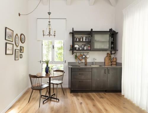 a kitchen with a table and chairs and a sink at שירת הגומא in Lahavot HaBashan