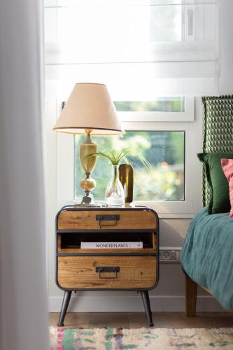 a nightstand with a lamp on top of it in a bedroom at שירת הגומא in Lahavot HaBashan