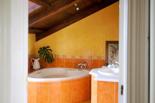 uma casa de banho com banheira e 2 lavatórios em Villa Várzea - Charming Suite na Várzea