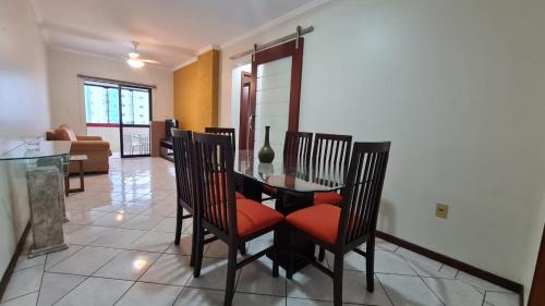 uma sala de jantar com uma mesa de vidro e cadeiras em Otimo apartamento em Balneário Camboriu em Balneário Camboriú