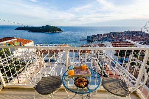balcón con mesa, sillas y vistas al océano en Apartments Dobroslavić, en Dubrovnik