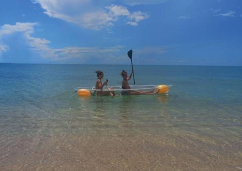 two children are sitting in a paddle boat in the water at 4U Resort Samui in Lamai