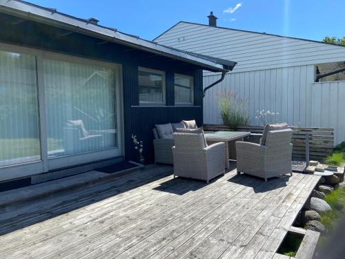un patio avec deux chaises et une table sur une terrasse dans l'établissement Nice place near the sea and forest, à Larvik