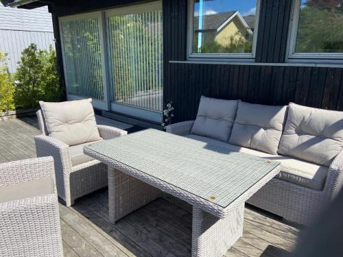 a patio with a table and two chairs and a couch at Nice place near the sea and forest in Larvik