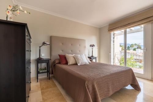 um quarto com uma cama grande e uma janela grande em Chalet Cortijo Blanco I em Marbella