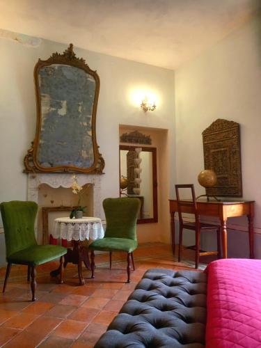 a living room with a table and green chairs at La Casa Rosa in Pigna