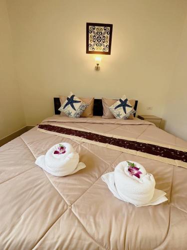 a bed with two towels on top of it at FairHouse khaolak in Khao Lak