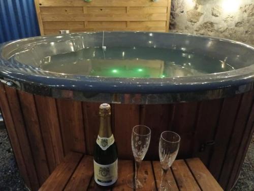 bañera de hidromasaje con botella de champán y 2 copas en Gite du Grand Chene, en Saint-Léger-Magnazeix