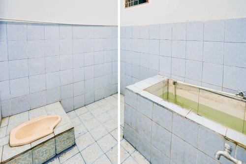 ein Badezimmer mit einem WC und einer Badewanne in der Unterkunft OYO Life 92046 Garuda Residence in Palembang