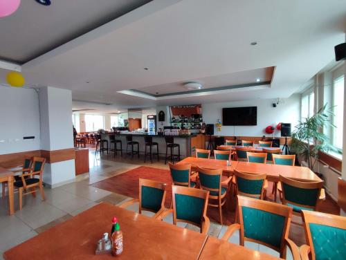ein Restaurant mit Tischen und Stühlen und eine Bar in der Unterkunft HOTEL JURKI Dom in Bratislava