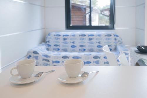 two cups and spoons sitting on a white table at Villaggio Smeraldo in Moneglia