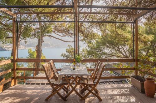 a table and chairs on a deck with a view of the water at Villaggio Smeraldo in Moneglia