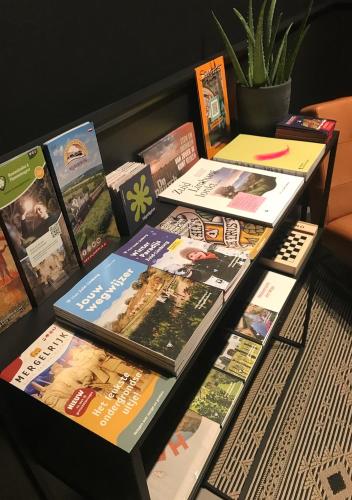 a table with a bunch of books on it at B&B De Oude Dorpsslagerij in Nuth